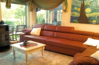 Wohnbereich mit Sofabett und Holzkamin
